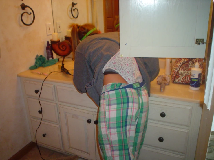 a woman bending over a towel in front of a sink