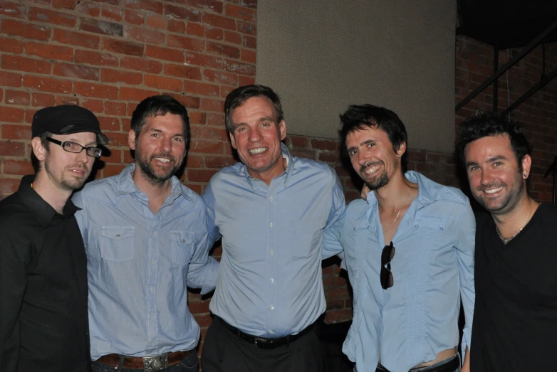 the five men smile while posing for a po