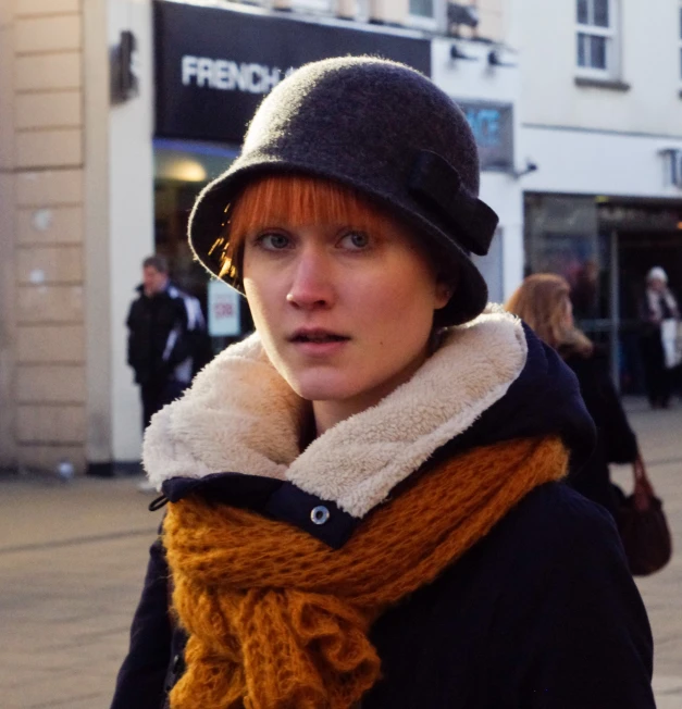 a woman is wearing a knit hat and scarf