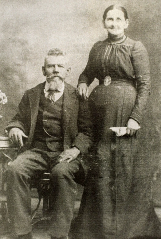 a couple dressed up in formal clothing posing for the camera
