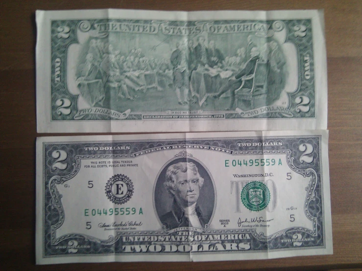 two pieces of paper money, one with an image of president john s