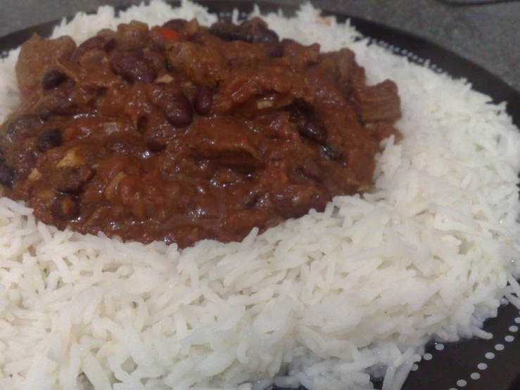 a black and white plate filled with rice and some chili