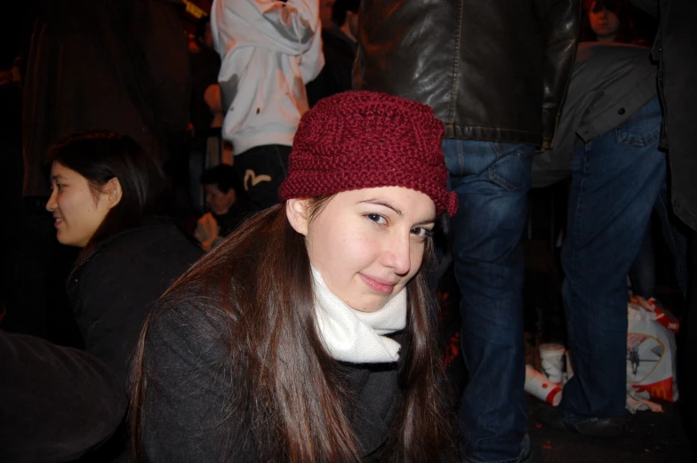a girl smiles at the camera while wearing a burgundy hat