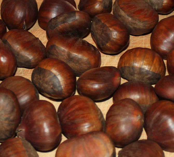 an arrangement of chestnut nuts on a wooden surface