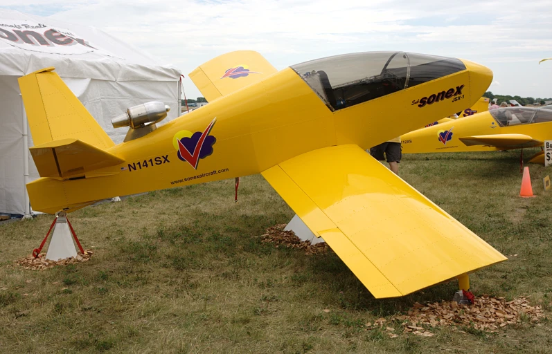 there are two yellow airplanes parked on the grass