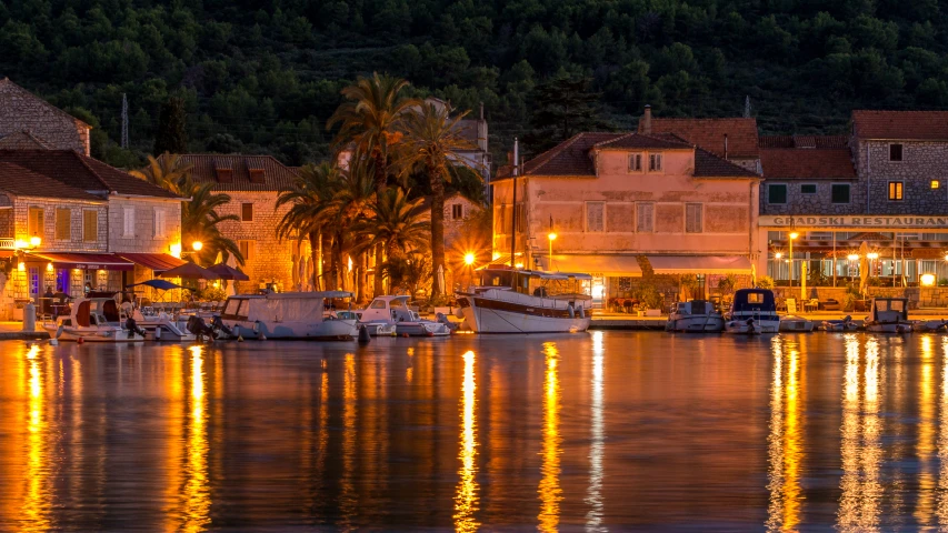 boats docked in the water near some buildings at night