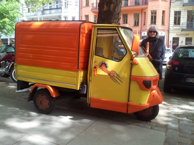 small orange and yellow truck parked next to building