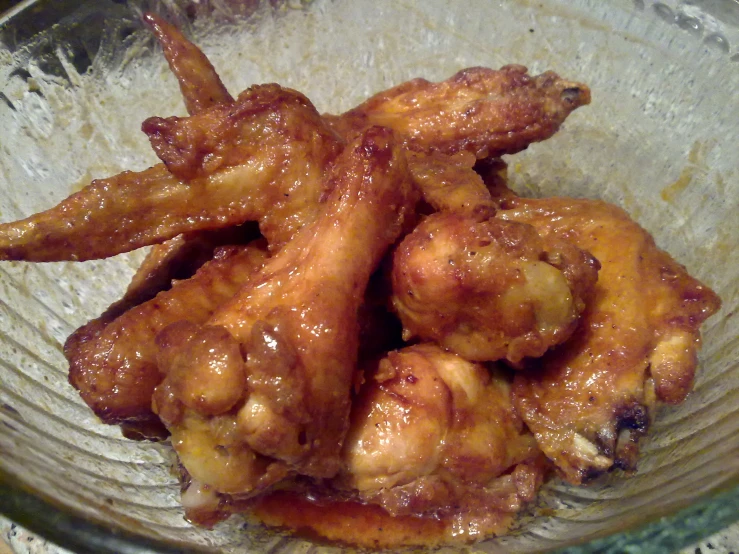 some chicken wings are in a bowl on a table