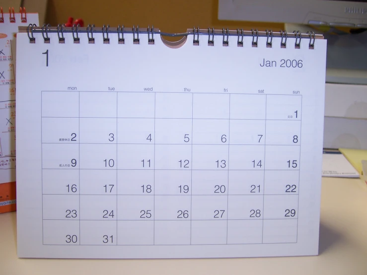 a calendar sitting on top of a desk next to a phone