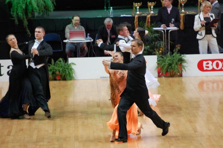 several people dressed in formal wear are on the dance floor