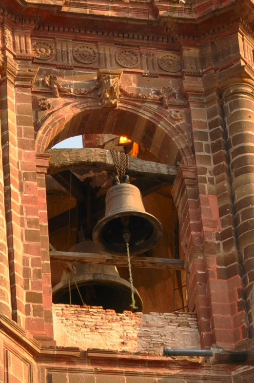 a clock tower with a metal bell and bells