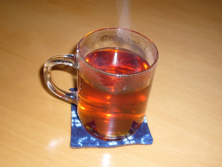 a glass of  tea is shown with steam coming out