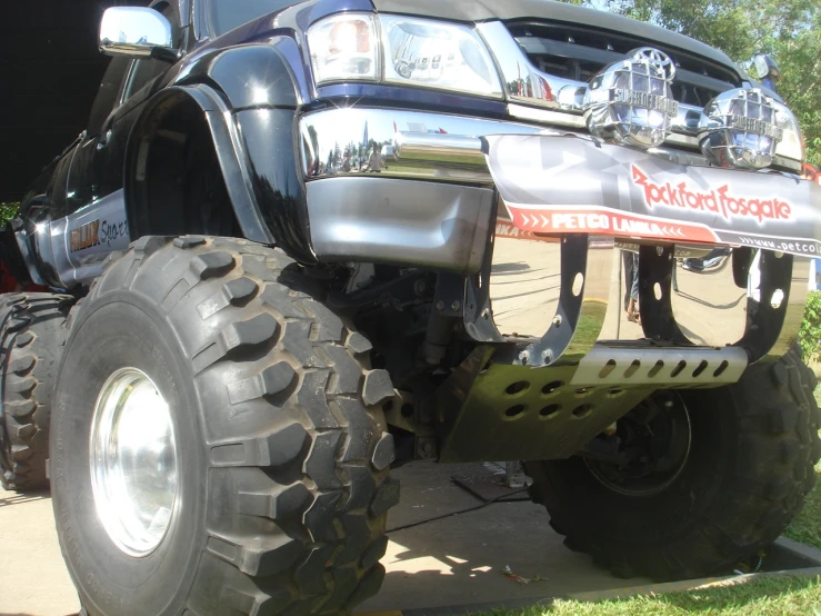 a large black lifted vehicle parked on the side of a road
