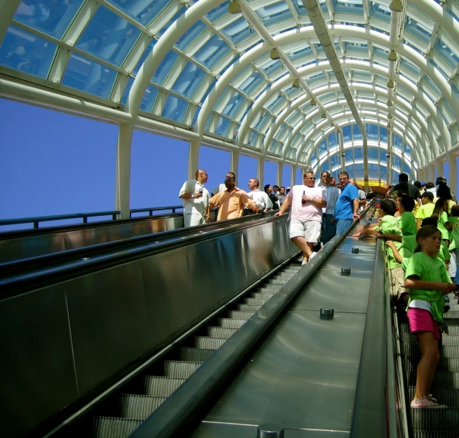 several people on an escalator ride on an empty train