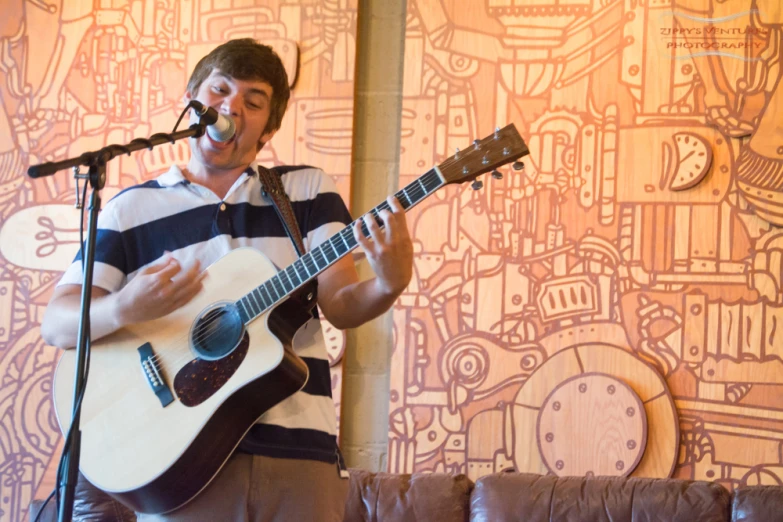 a man on stage playing guitar with a microphone