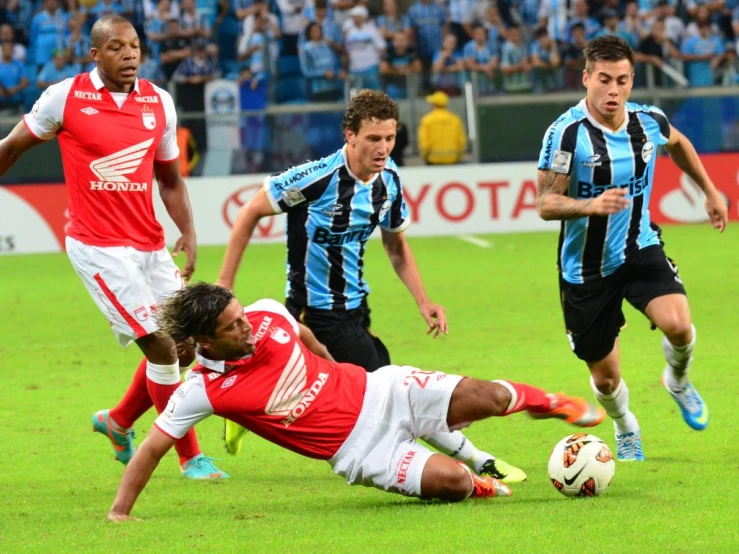 three men on different teams playing a soccer match