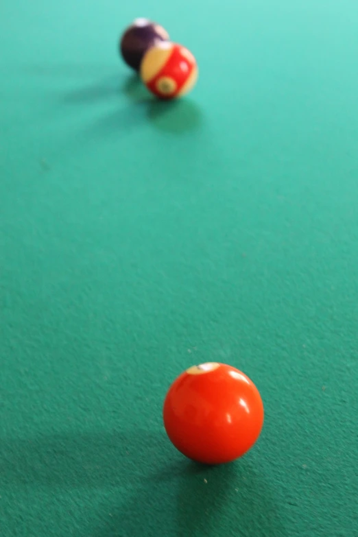 three balls and two billows on a green table