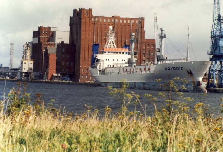 a large ship sitting on the water next to a dock