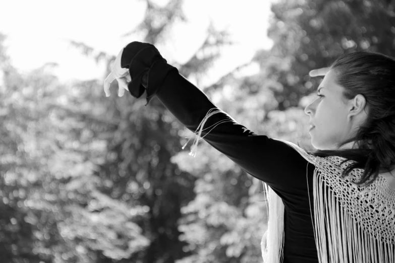 a woman holding up a white bird while wearing fringes