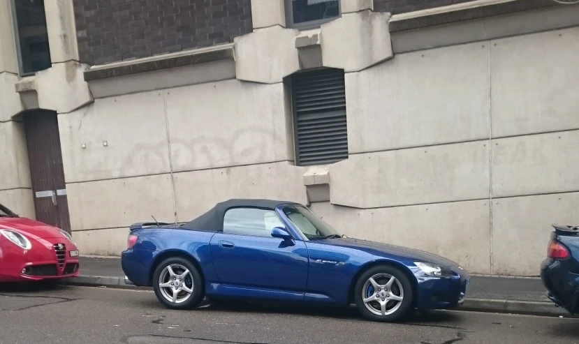 two cars parked next to each other on the side of a road