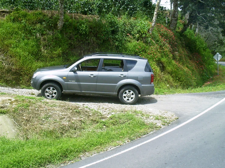 a grey four - doored truck parked by the side of a road