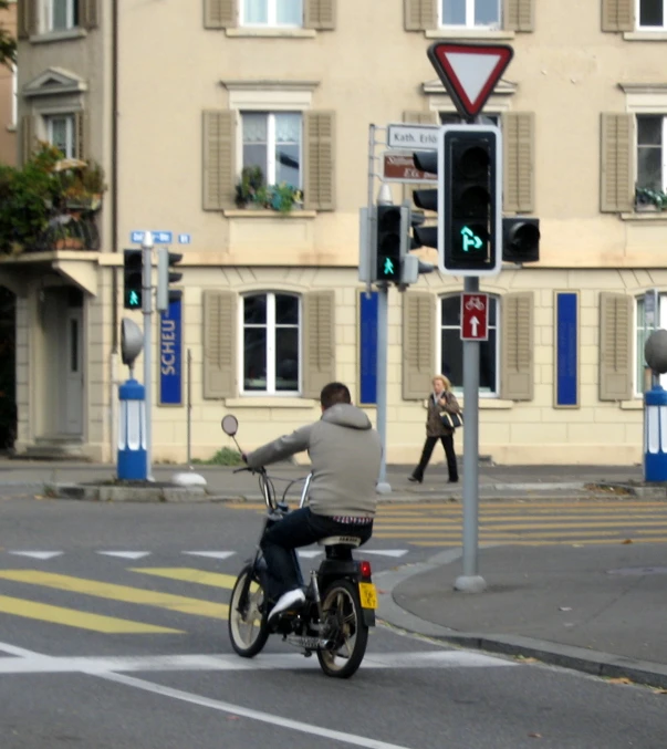 a person riding a motorcycle next to a traffic light