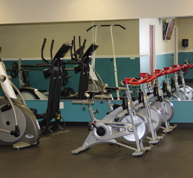 a gym room with various exercise bikes on it