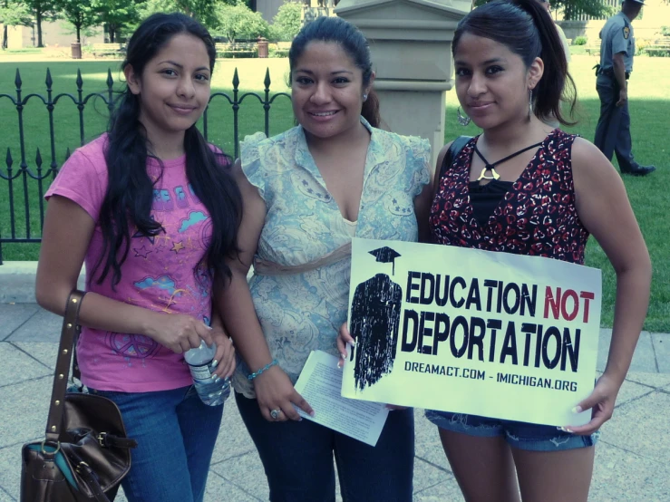 three girls holding up a sign saying education not deportation