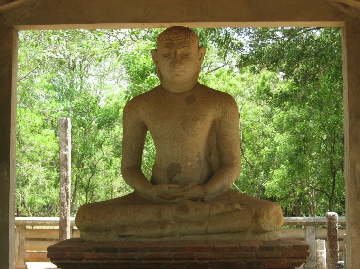 a statue is sitting in a position and meditating