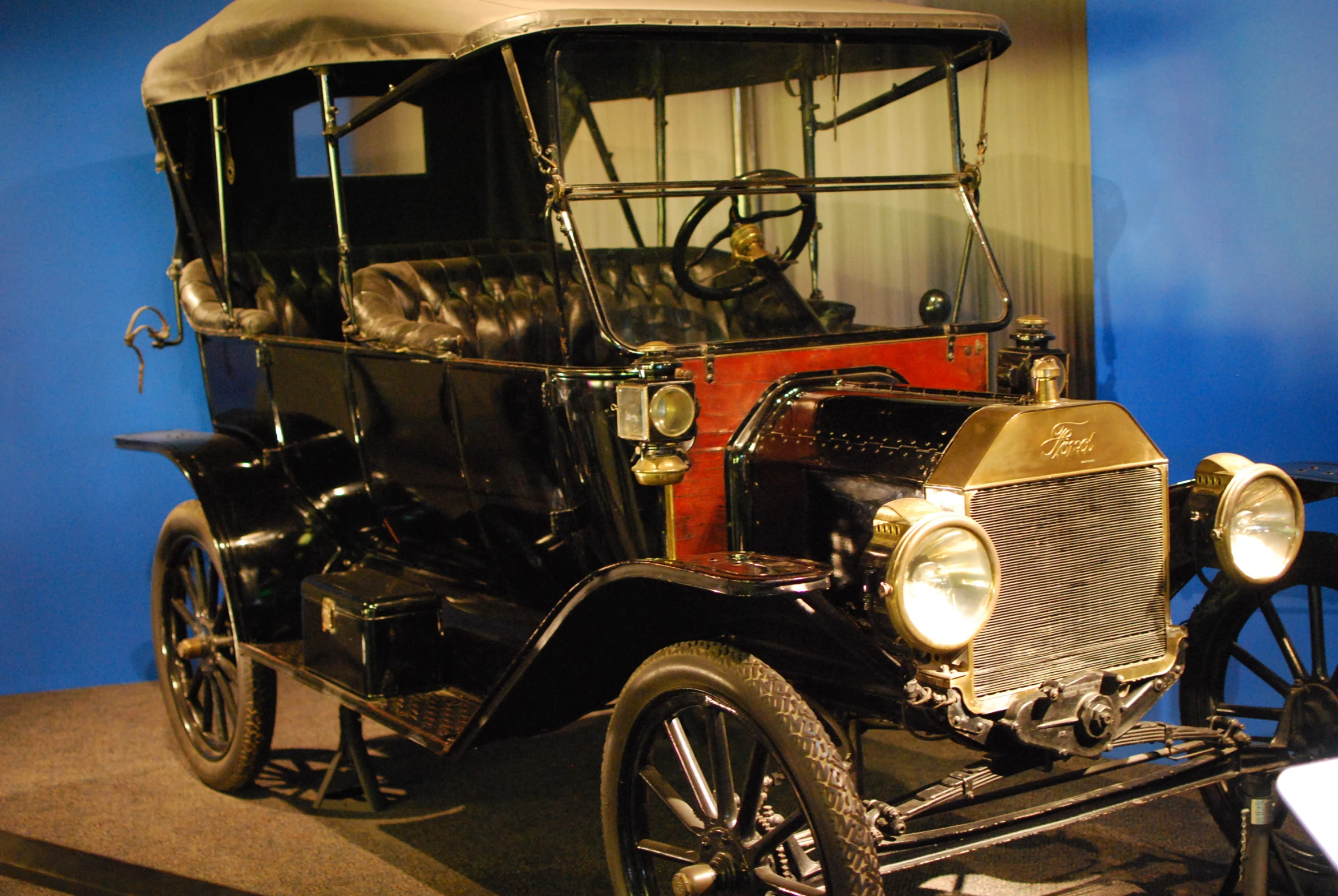 an old fashion car on display in a museum