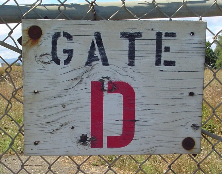 a sign that says gate on the side of the fence