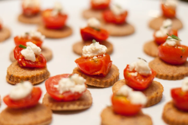 tiny ers with tomatoes and cream cheese on them