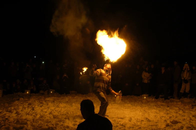 a man holding a fire can in the dark