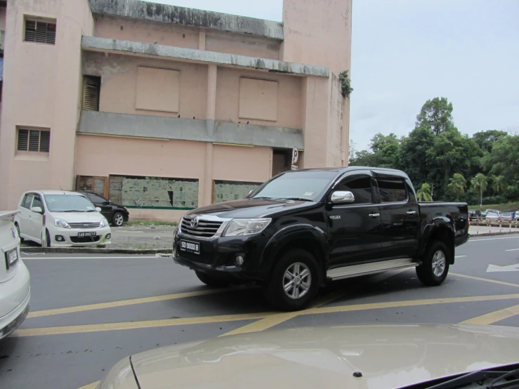 a large black truck parked at a stop light