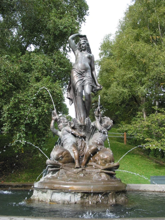 the water feature in the park features a bronze statue