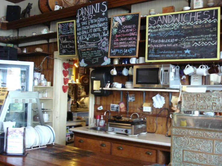 an open restaurant counter with signs on the wall