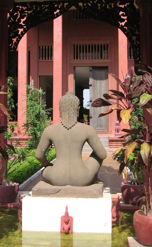 a woman statue sitting in front of a building