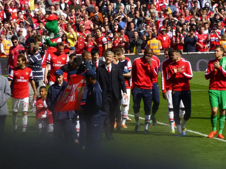 a group of men standing on top of a soccer field