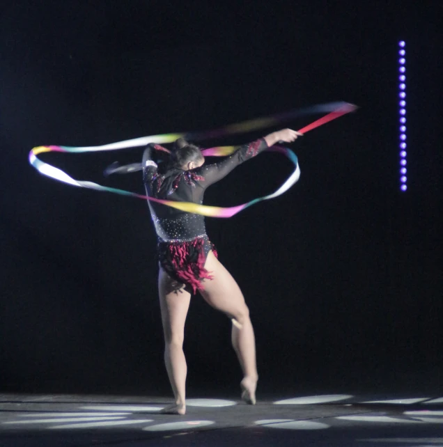 a woman standing on a stage holding a hula hoop