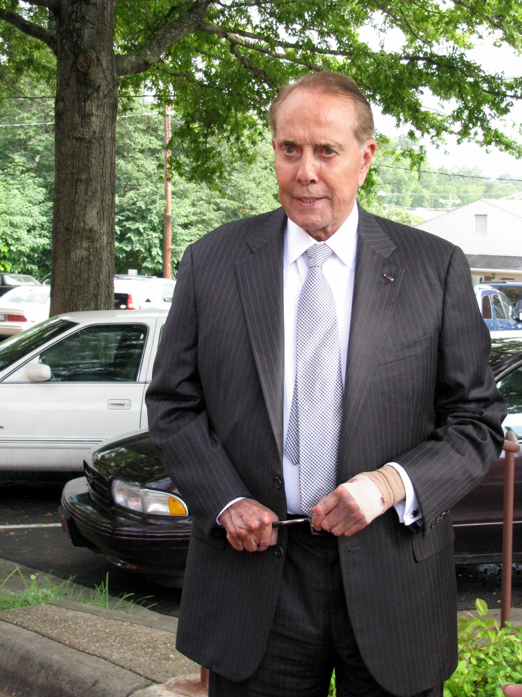 a man in business attire standing by a street