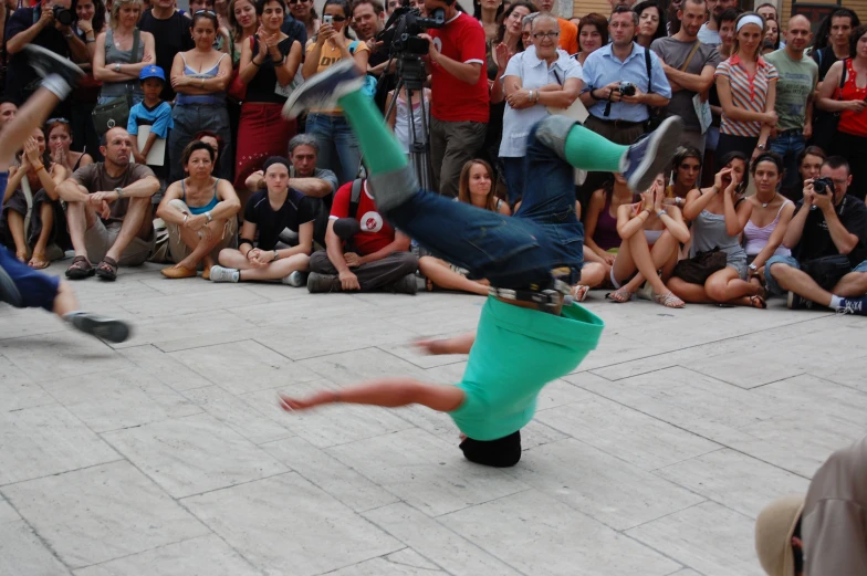 a skateboarder in the air during a trick in front of a crowd