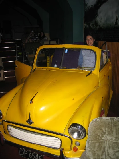 a yellow car is sitting on display in a museum