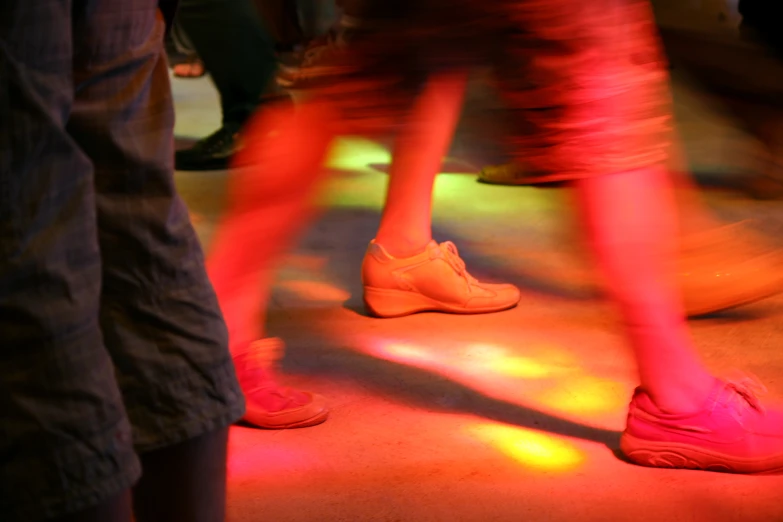 two people dancing with pink sneakers on