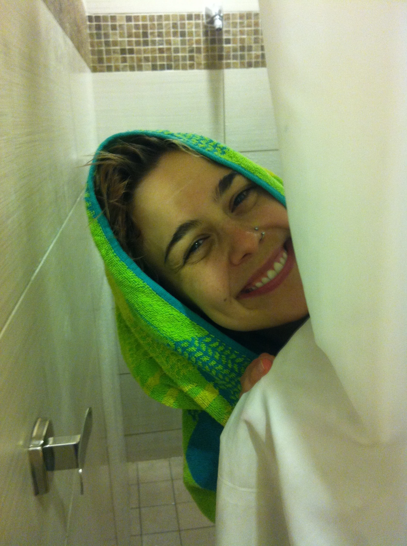 a woman smiles from behind the curtain while covering her face