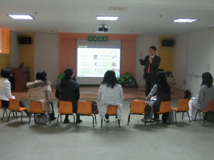 a person speaking at a seminar in a room