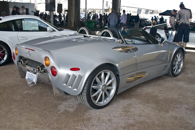 a shiny silver sports car with a shiny yellow rim