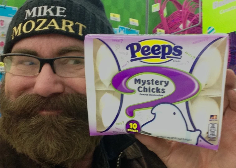 man with eyeglasses holds up a peeps mystery checks box