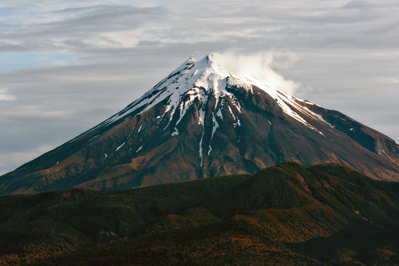 a large snowy mountain that has some white clouds