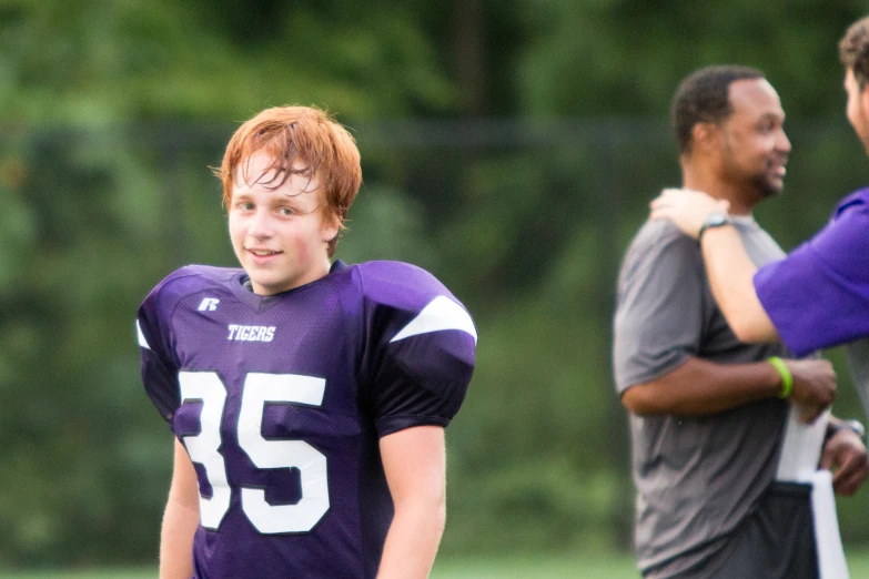 the young man is standing with his arms around his neck