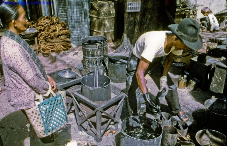 two people work on buckets in an open market